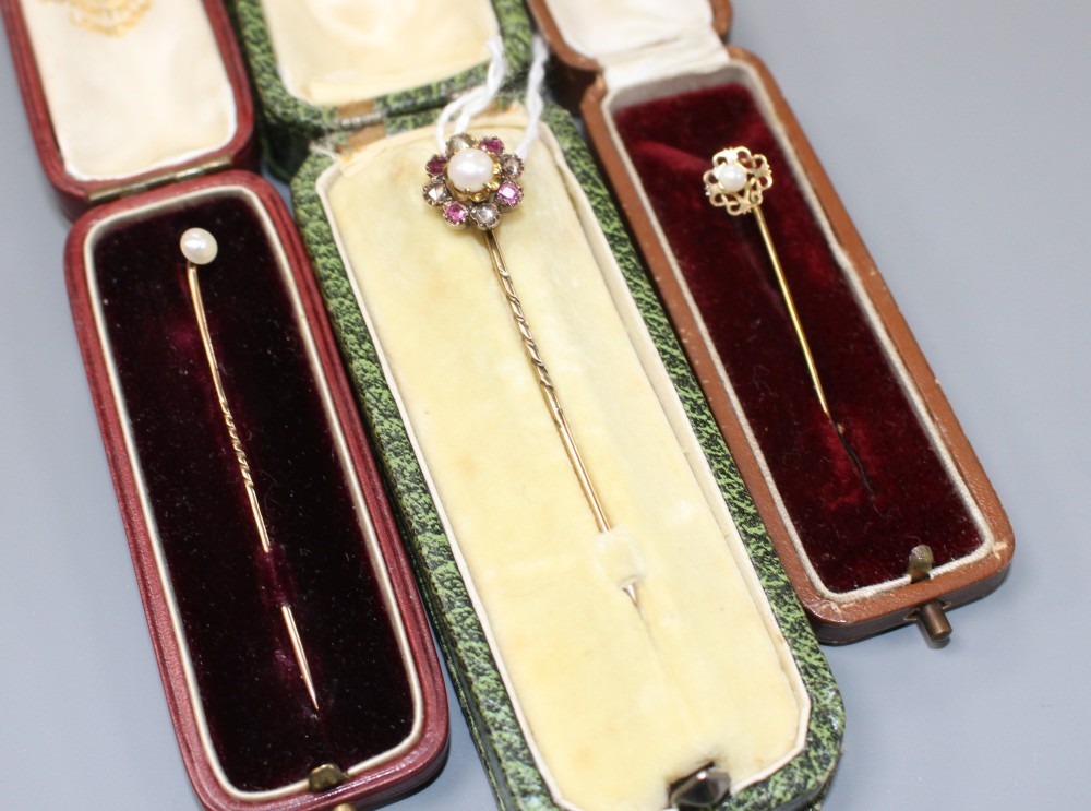 Three assorted yellow metal and gem set stick pins
